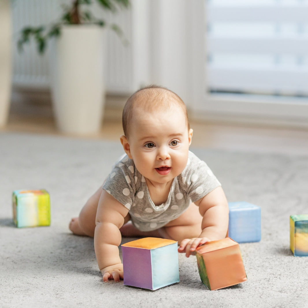Baby playing with colorful blocks on a carpeted floor