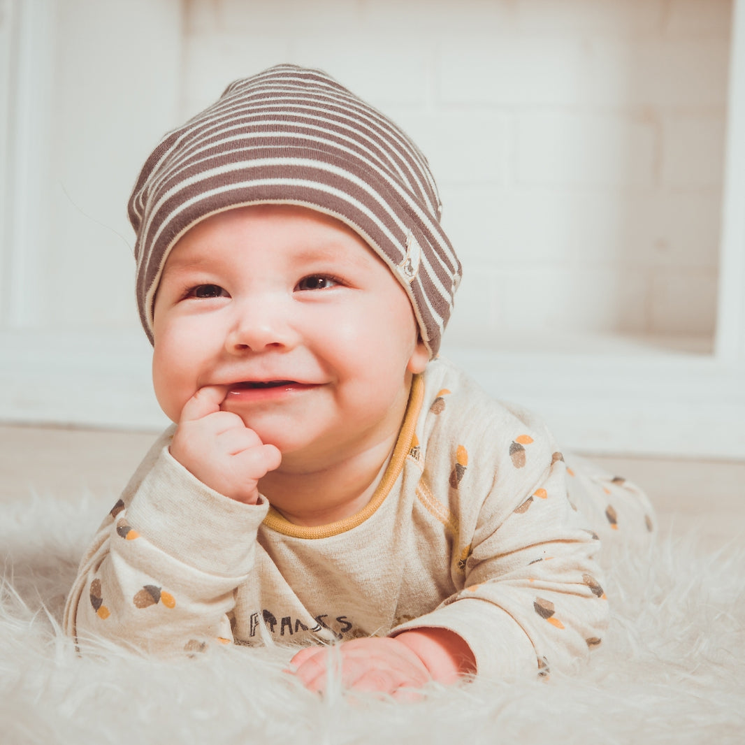 Baby wearing a striped hat and smiling